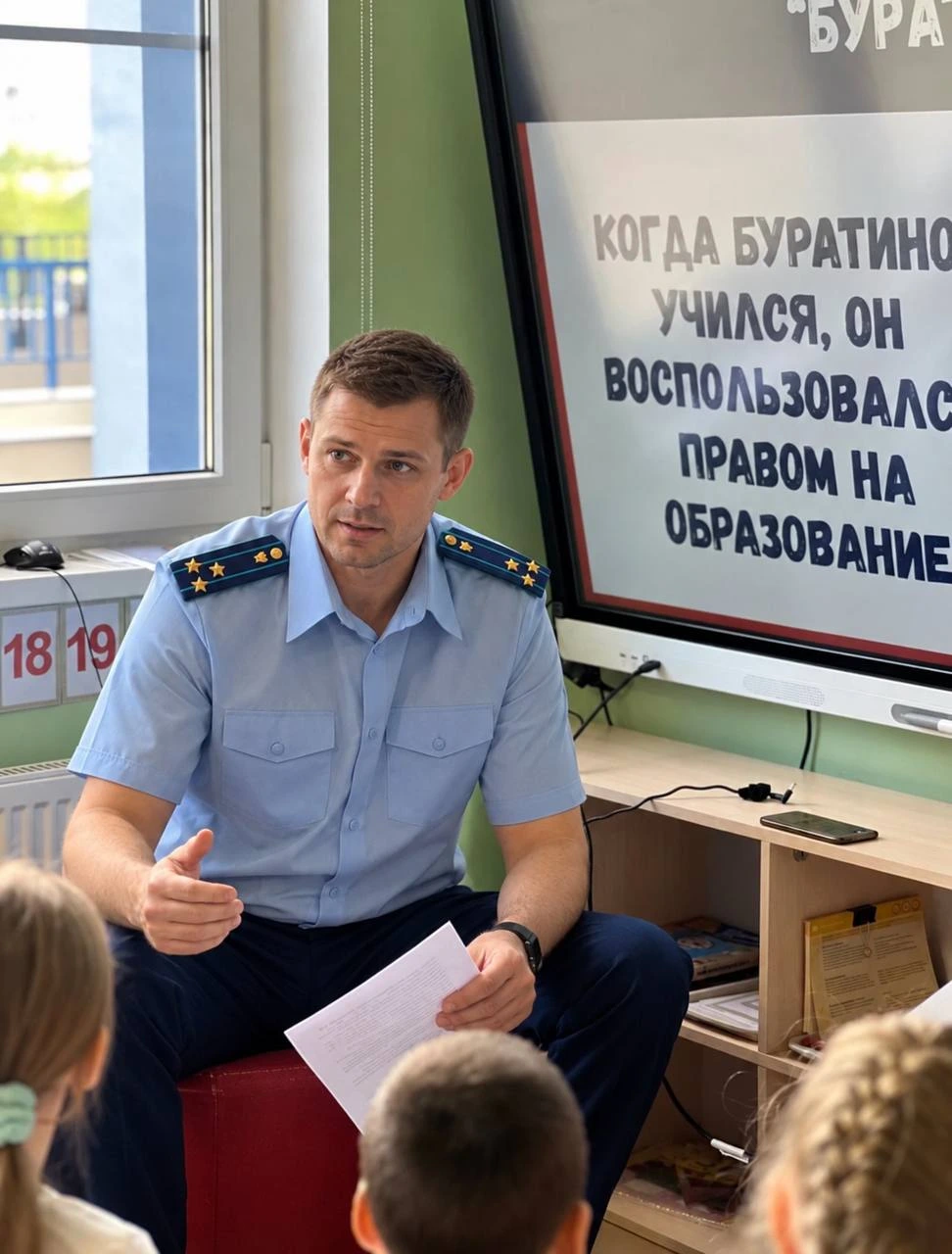 Приглашённый гость в форме беседует с детьми в группе