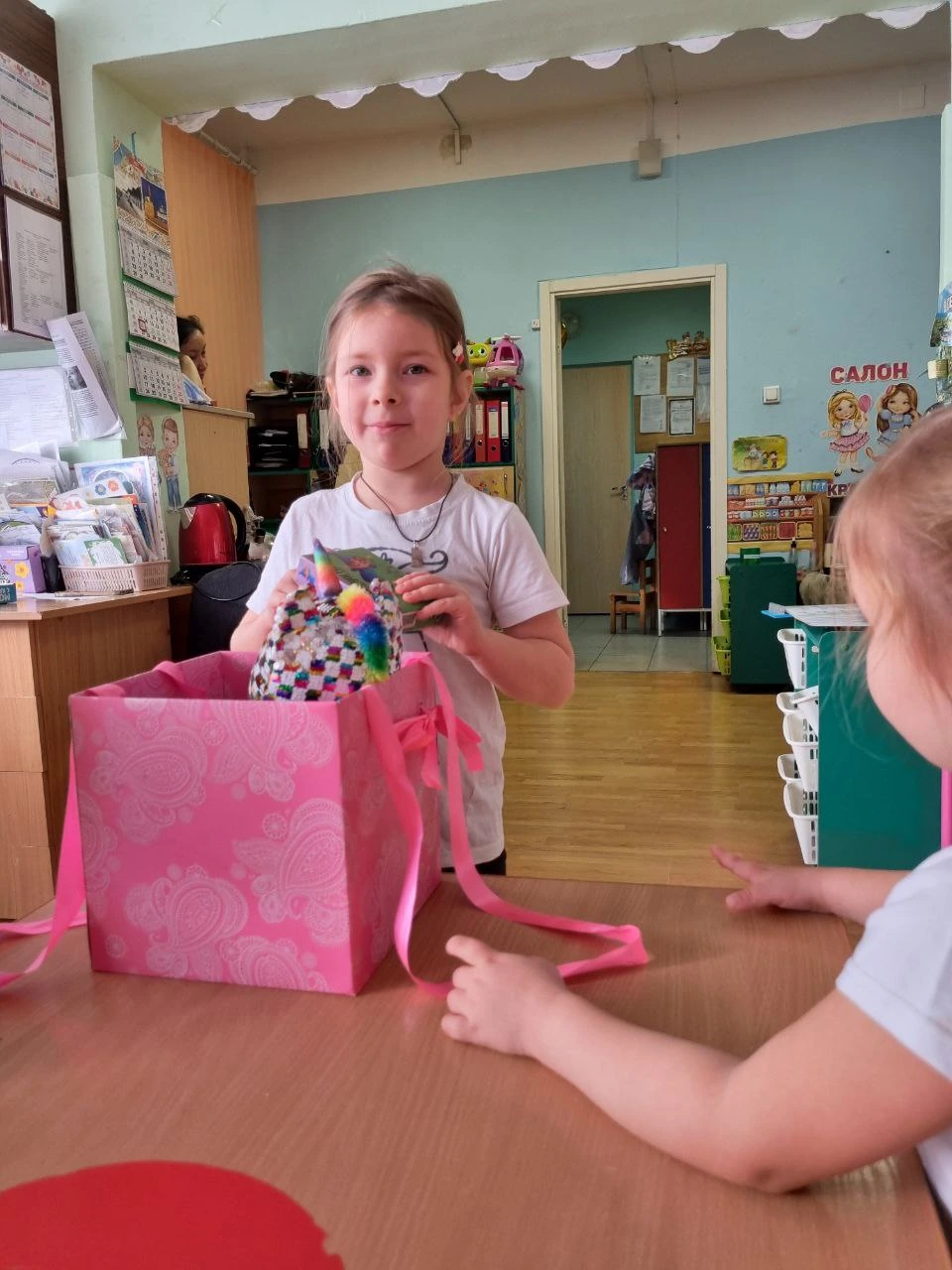 Девочка показывает сделанную своими руками игрушку